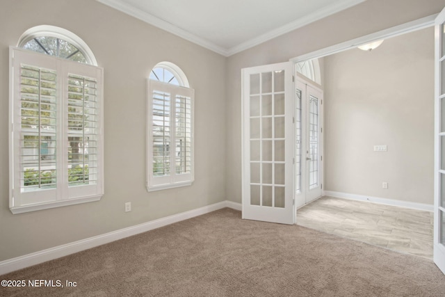 carpeted empty room with baseboards, ornamental molding, and french doors