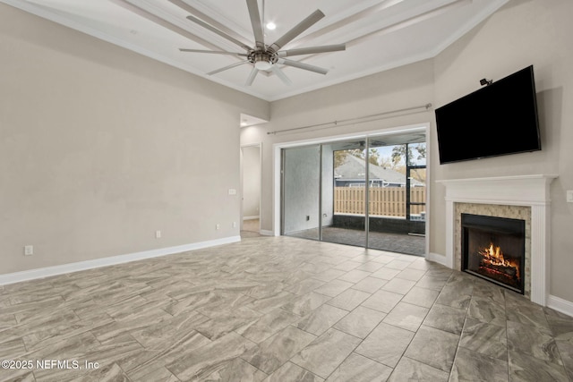 unfurnished living room featuring marble finish floor, a ceiling fan, ornamental molding, baseboards, and a fireplace