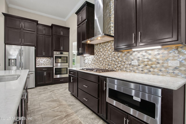 kitchen with crown molding, dark brown cabinets, tasteful backsplash, stainless steel appliances, and wall chimney exhaust hood