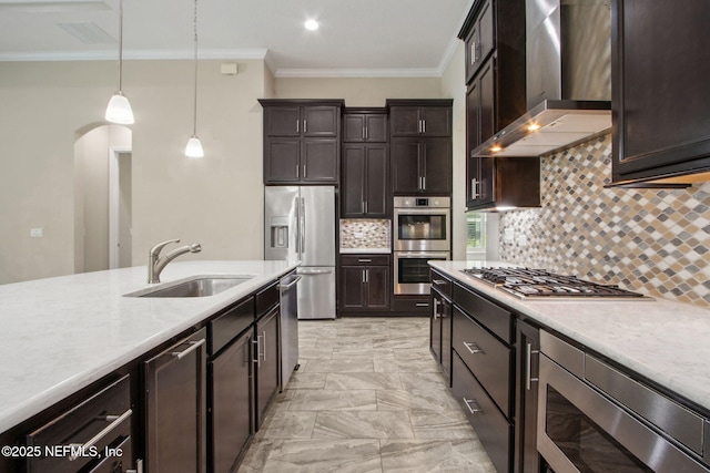 kitchen featuring stainless steel appliances, a sink, wall chimney range hood, marble finish floor, and crown molding