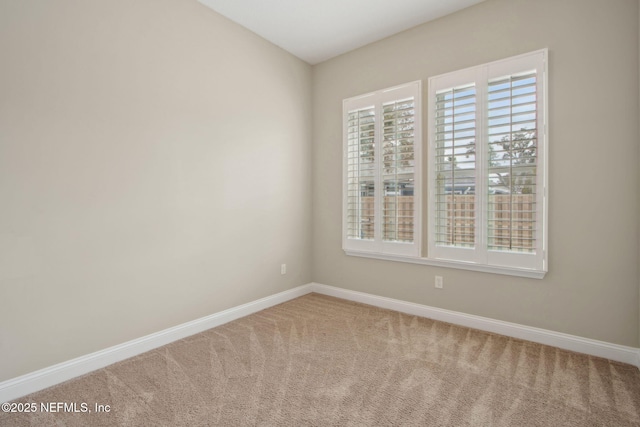 carpeted empty room with baseboards