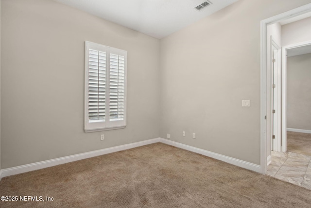 carpeted spare room with baseboards and visible vents