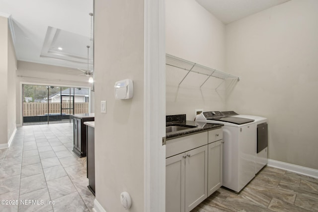 laundry room with marble finish floor, baseboards, a sink, and independent washer and dryer