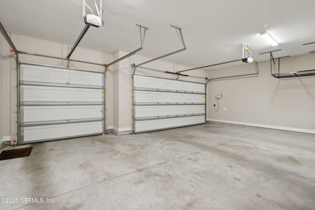 garage with baseboards and a garage door opener