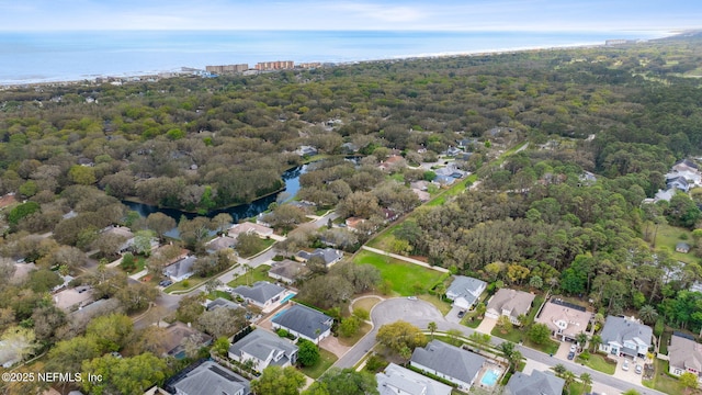 birds eye view of property with a residential view, a wooded view, and a water view