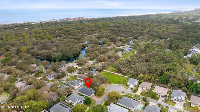 aerial view with a residential view, a view of trees, and a water view