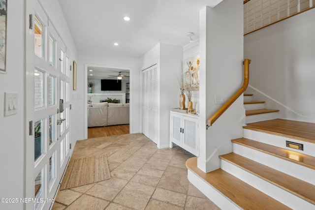 entryway featuring recessed lighting, stone tile floors, ceiling fan, stairs, and baseboards