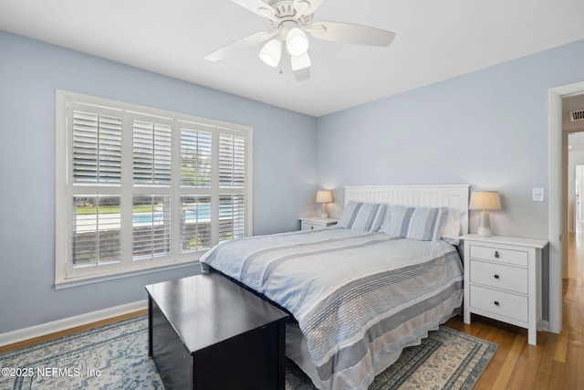 bedroom featuring baseboards, wood finished floors, and ceiling fan