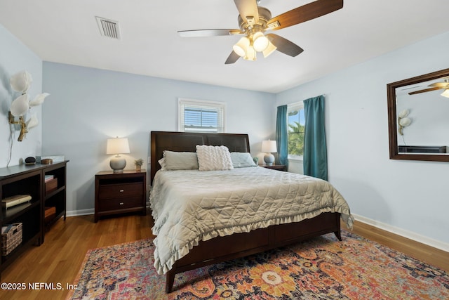 bedroom featuring wood finished floors, visible vents, and baseboards