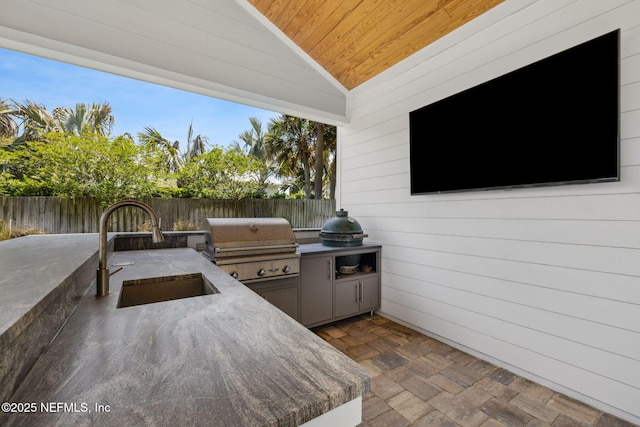 view of patio / terrace with a sink, a grill, exterior kitchen, and fence