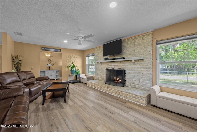 226 E Minnesota Ave, Macclenny, FL 32063 - living area featuring a large fireplace, ceiling fan, visible vents, and a textured ceiling