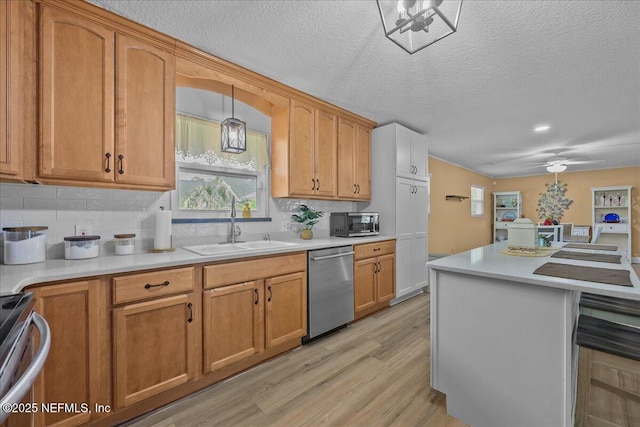226 E Minnesota Ave, Macclenny, FL 32063 - kitchen with light wood-style flooring, a sink, stainless steel appliances, backsplash, and light countertops