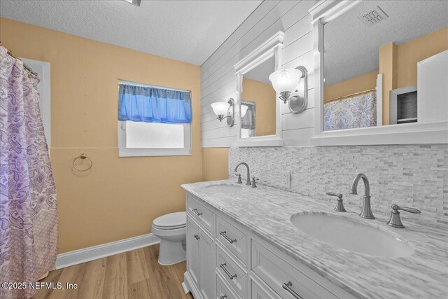 226 E Minnesota Ave, Macclenny, FL 32063 - full bath with a sink, decorative backsplash, visible vents, and wood finished floors