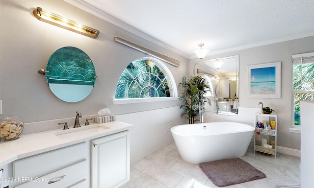 bathroom with a textured ceiling, a freestanding tub, crown molding, and vanity