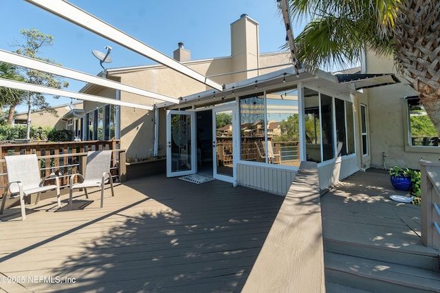 wooden deck with a sunroom