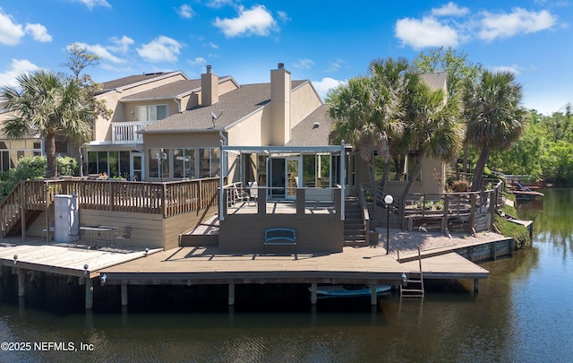 dock area featuring a deck with water view, stairs, and a balcony