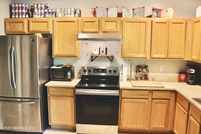 1845 Lago Del Sur Dr, Middleburg, FL 32068 - kitchen with appliances with stainless steel finishes, under cabinet range hood, light countertops, and light brown cabinets