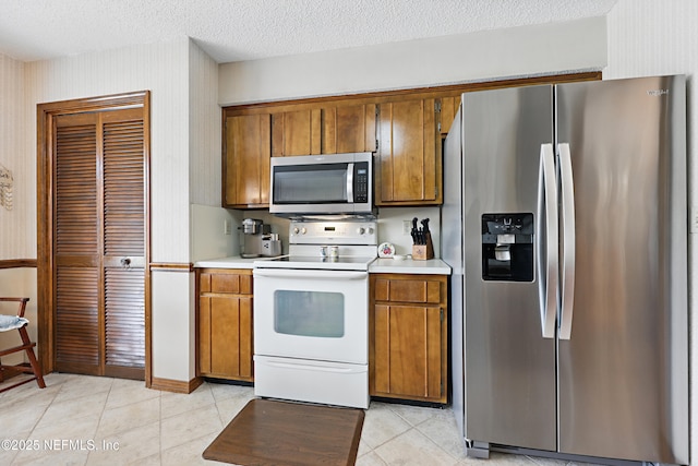2629 Sandlewood Cir, Orange Park, FL 32065 - kitchen with appliances with stainless steel finishes, light tile patterned floors, light countertops, and brown cabinetry