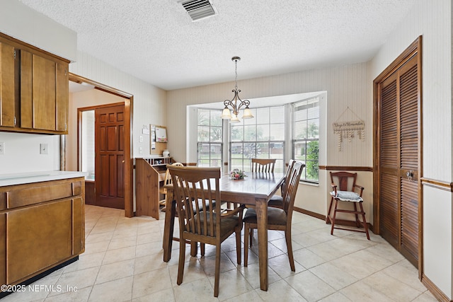 2629 Sandlewood Cir, Orange Park, FL 32065 - dining room featuring wallpapered walls, light tile patterned floors, visible vents, a notable chandelier, and a textured ceiling