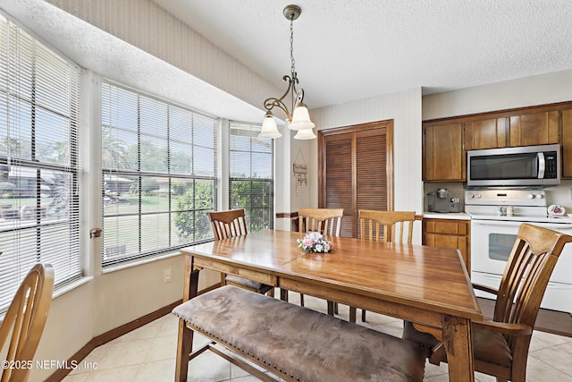 2629 Sandlewood Cir, Orange Park, FL 32065 - dining room featuring light tile patterned floors, a textured ceiling, and baseboards