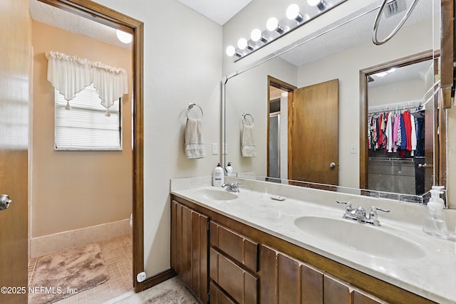 2629 Sandlewood Cir, Orange Park, FL 32065 - bathroom featuring a walk in closet, double vanity, a sink, and tile patterned floors