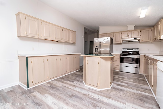 kitchen with lofted ceiling, under cabinet range hood, stainless steel appliances, light countertops, and a center island