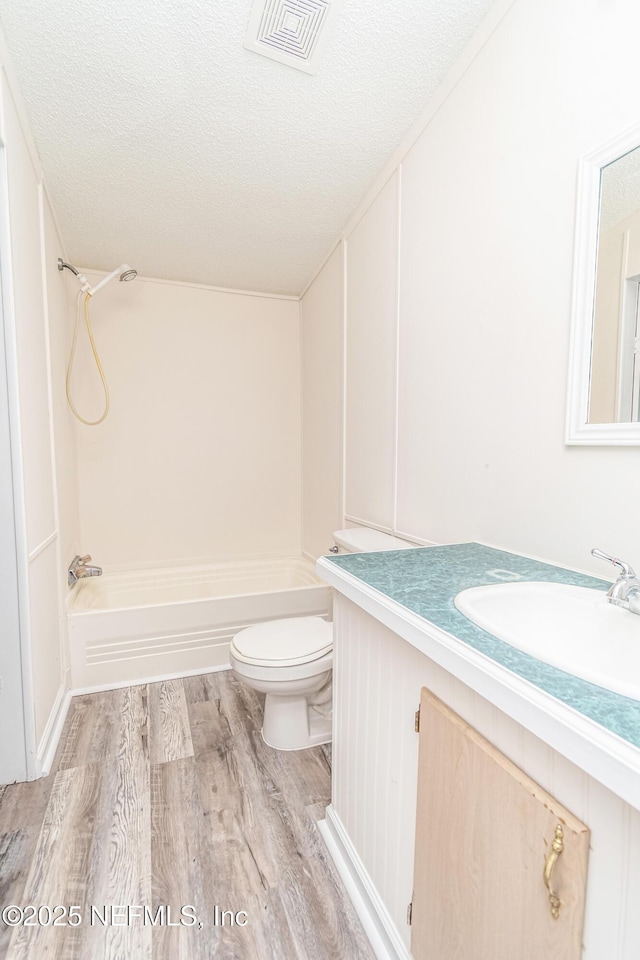 full bath with wood finished floors, bathing tub / shower combination, visible vents, and toilet