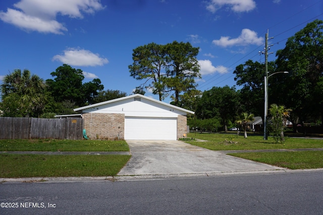 ranch-style home featuring fence, concrete driveway, brick siding, and a front lawn