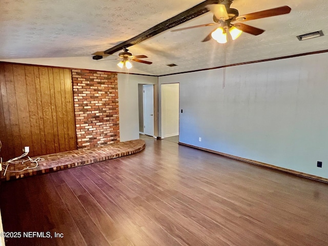 spare room with a ceiling fan, visible vents, wood finished floors, and a textured ceiling