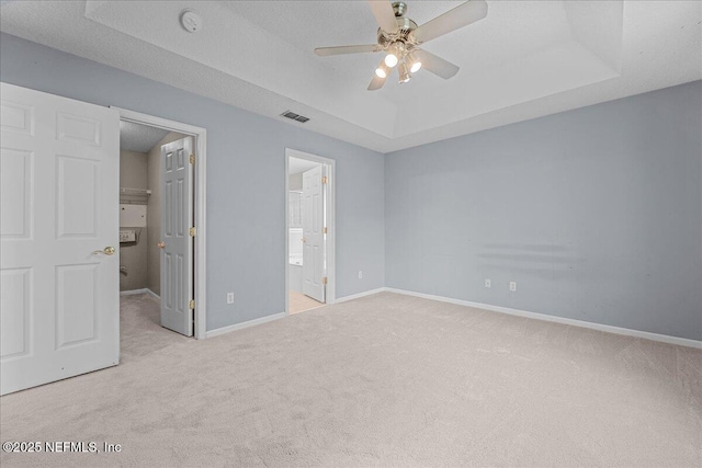 1884 Lake Forest Ln, Fleming Island, FL 32003 - unfurnished bedroom featuring a tray ceiling, a spacious closet, carpet flooring, and baseboards