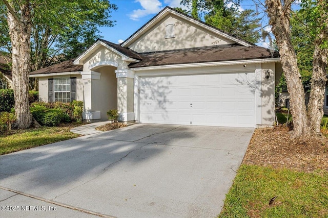 1884 Lake Forest Ln, Fleming Island, FL 32003 - view of front of house featuring a garage, roof with shingles, concrete driveway, and stucco siding