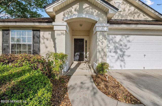 1884 Lake Forest Ln, Fleming Island, FL 32003 - entrance to property with stucco siding, a shingled roof, and a garage