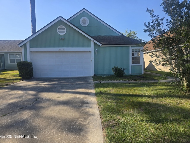 view of front of house with an attached garage, a shingled roof, a front yard, and concrete driveway