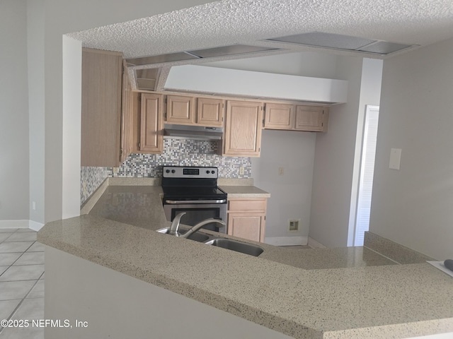kitchen featuring a peninsula, a sink, backsplash, stainless steel range with electric stovetop, and under cabinet range hood