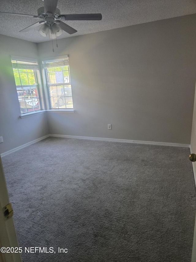 carpeted spare room with baseboards, a ceiling fan, and a textured ceiling