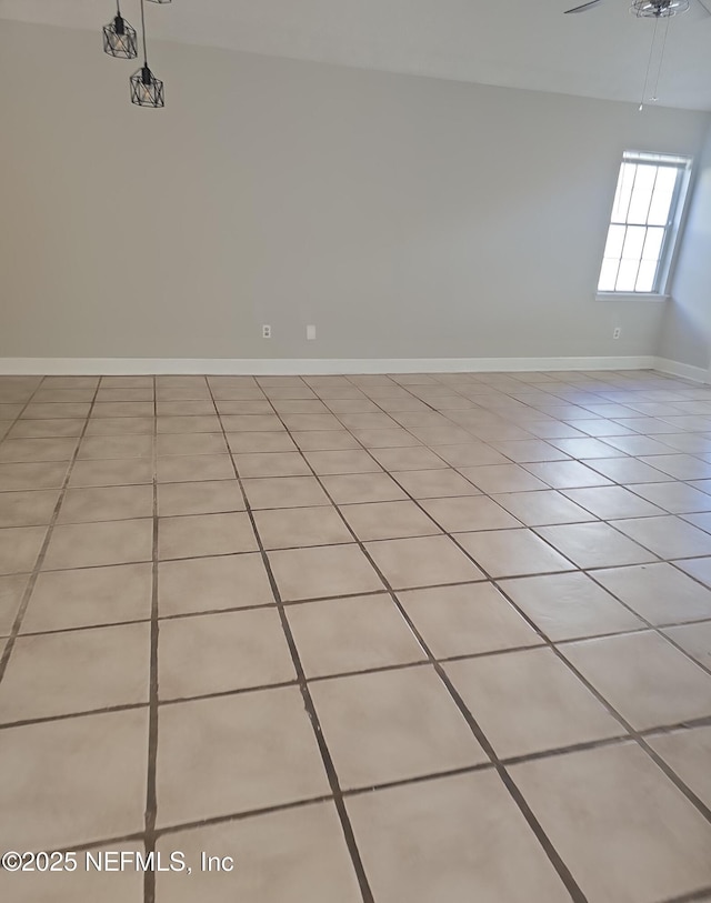 unfurnished room featuring baseboards and light tile patterned floors