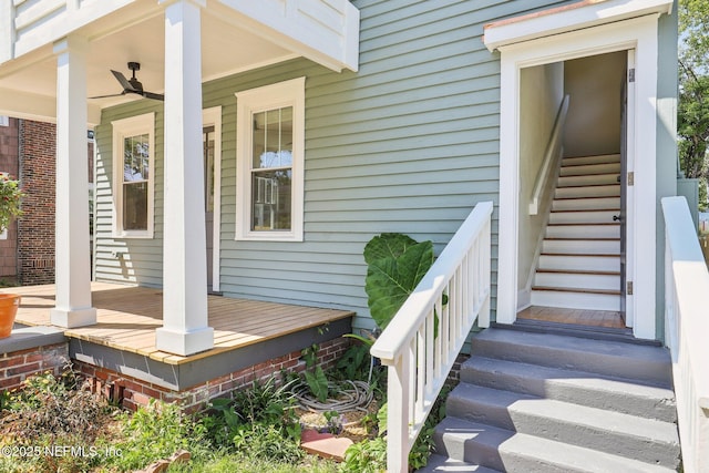 view of exterior entry featuring ceiling fan and covered porch