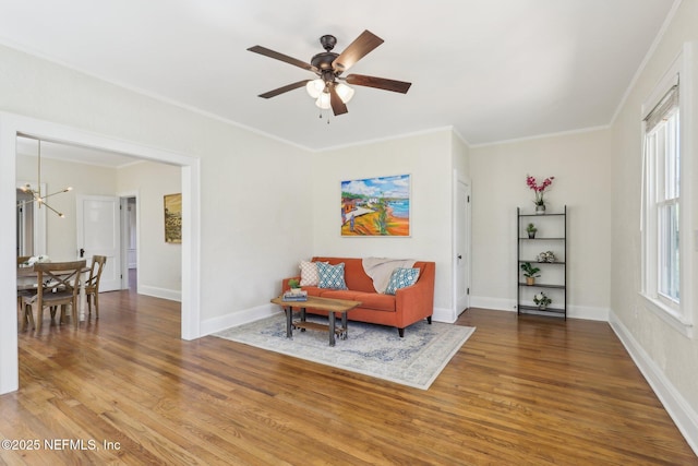 sitting room with baseboards, wood finished floors, and ceiling fan with notable chandelier