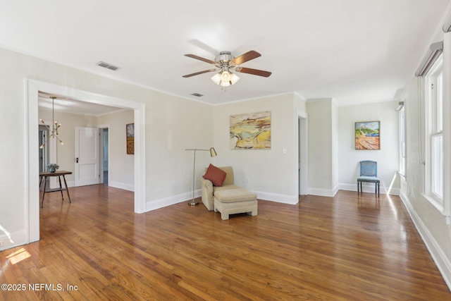 living area with baseboards, wood finished floors, visible vents, and a ceiling fan