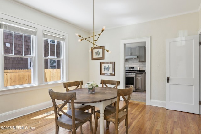 dining room with plenty of natural light, baseboards, light wood-style floors, and a chandelier