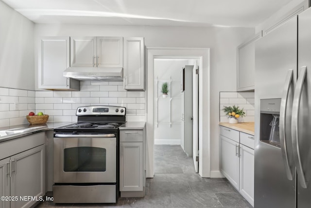 kitchen featuring tasteful backsplash, gray cabinets, appliances with stainless steel finishes, light countertops, and under cabinet range hood