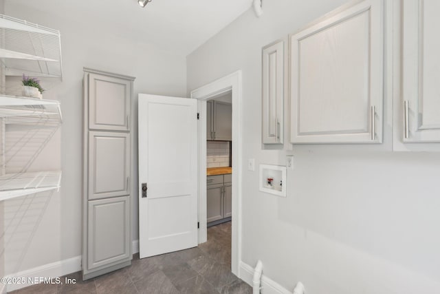 laundry area featuring cabinet space, hookup for a washing machine, and baseboards