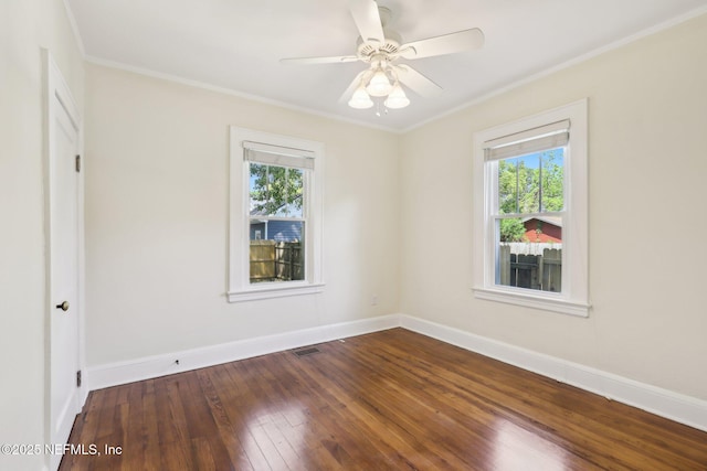 spare room featuring hardwood / wood-style flooring, visible vents, ornamental molding, and a healthy amount of sunlight