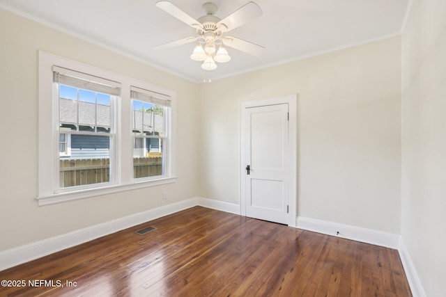 empty room with visible vents, hardwood / wood-style flooring, and ornamental molding