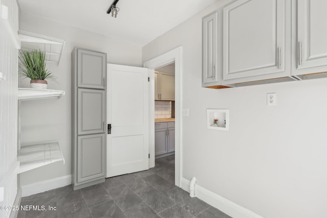 laundry area featuring cabinet space, hookup for a washing machine, and baseboards