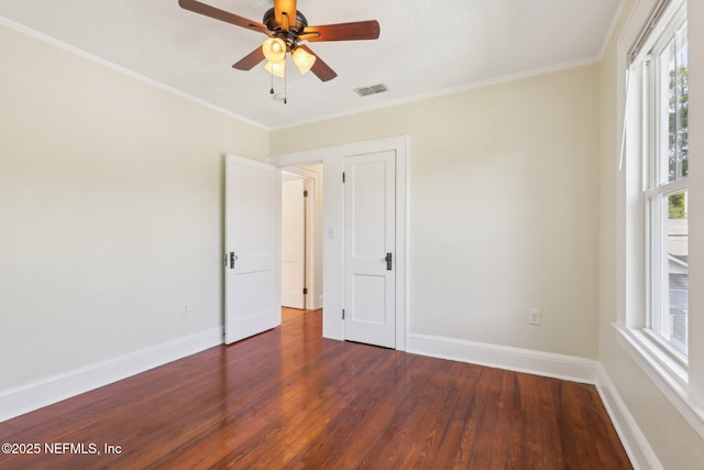 empty room featuring visible vents, plenty of natural light, and wood finished floors