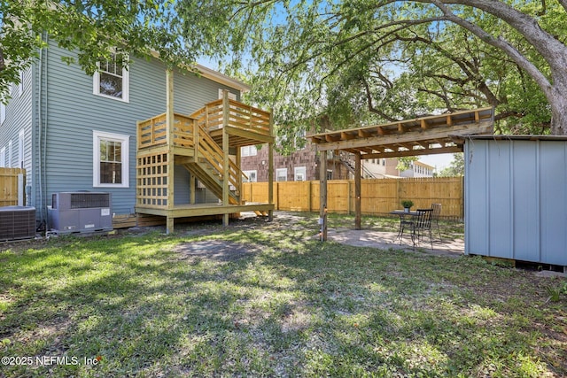 rear view of house featuring central AC, a wooden deck, a fenced backyard, and a lawn