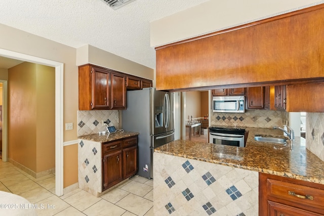 930 Ironridge Ct, Orange Park, FL 32065 - kitchen featuring stainless steel appliances, a sink, stone counters, decorative backsplash, and light tile patterned floors
