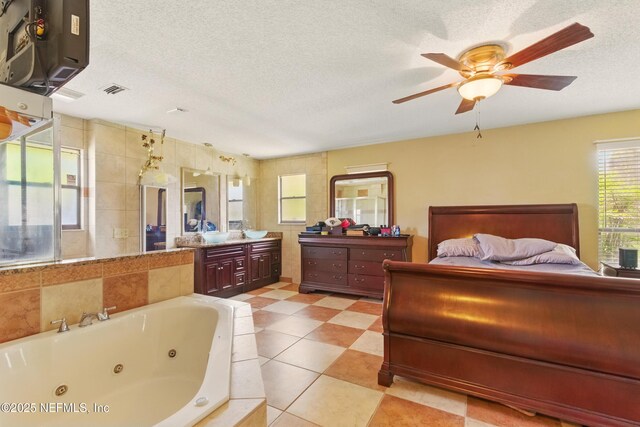 930 Ironridge Ct, Orange Park, FL 32065 - bathroom featuring a textured ceiling, visible vents, a ceiling fan, a whirlpool tub, and vanity