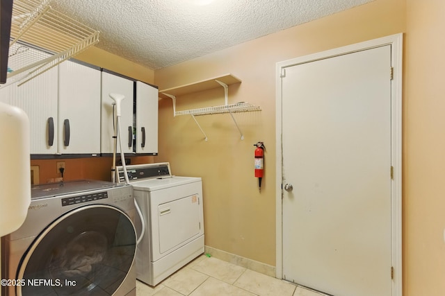 930 Ironridge Ct, Orange Park, FL 32065 - clothes washing area featuring independent washer and dryer, a textured ceiling, light tile patterned floors, and cabinet space